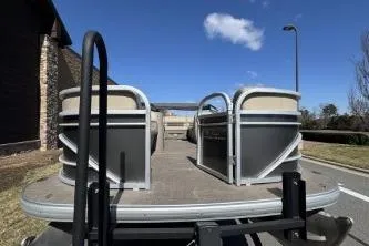 Slide: The Image of 2021 Sun Tracker Party Barge 20 DLX pontoon boat on trailer, outdoor setting. - 6