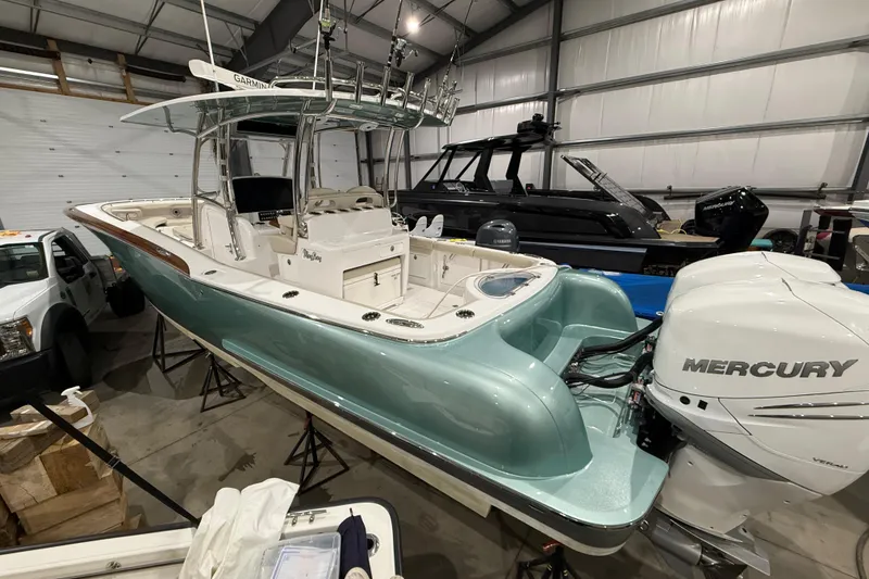 Slide: The Image of 2021 Mag Bay 33 CC boat in showroom, featuring sleek design and polished wood accents. - 13