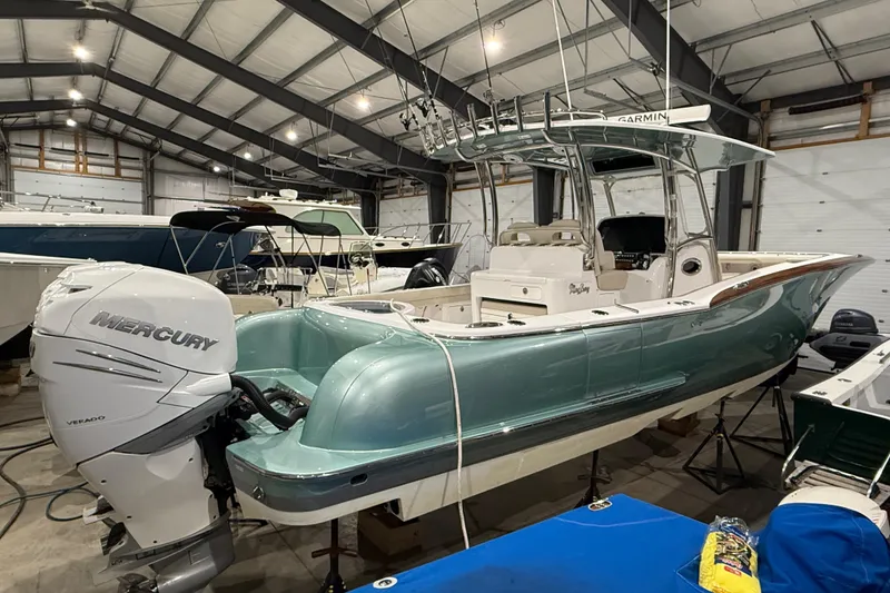 Slide: The Image of 2021 Mag Bay 33 CC boat in storage, viewed from below, showcasing sleek hull design. - 14