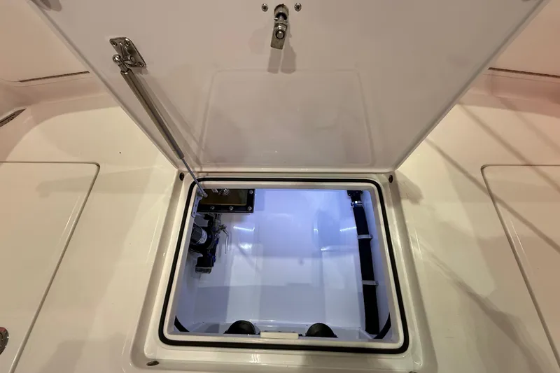 Slide: The Image of 2021 Mag Bay 33 CC boat interior with cushioned seating and storage compartment. - 52