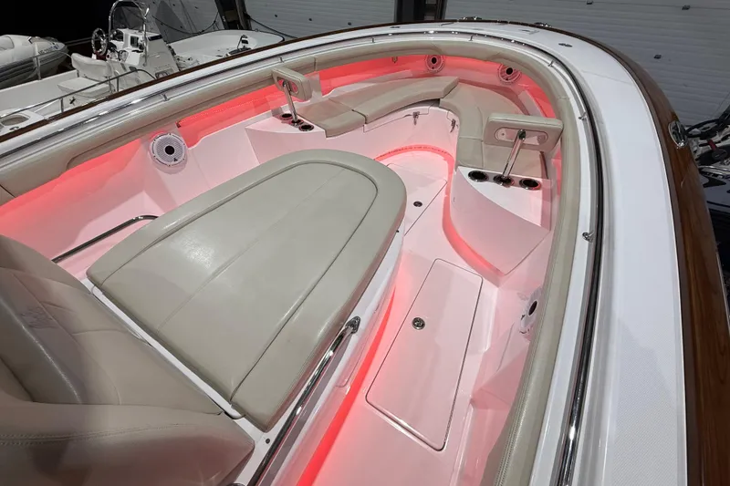 Slide: The Image of 2021 Mag Bay 33 CC boat storage compartment with organized tackle boxes and red LED lighting. - 72