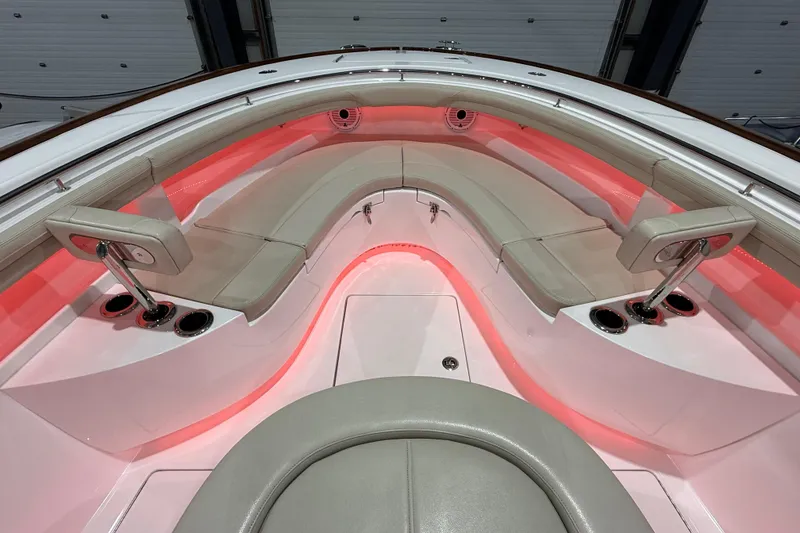 Slide: The Image of 2021 Mag Bay 33 CC boat interior with red LED lighting and cushioned seating. - 75