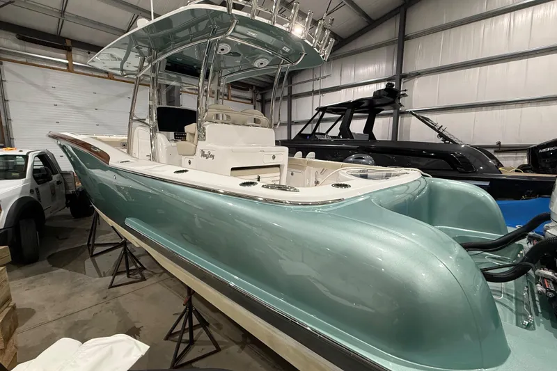 Slide: The Image of 2021 Mag Bay 33 CC boat with red interior lighting, docked at sunset. - 9