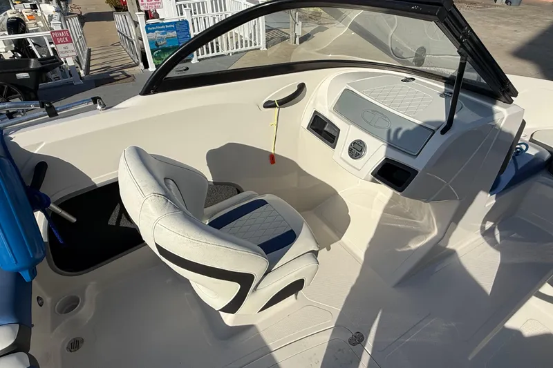 Slide: The Image of 2016 Tahoe 450 TS boat interior with steering console and cushioned seat. - 13