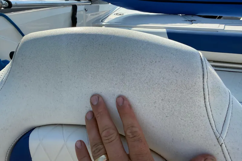 Slide: The Image of Close-up of 2016 Tahoe 450 TS boat seat with hand touching white upholstery. - 17