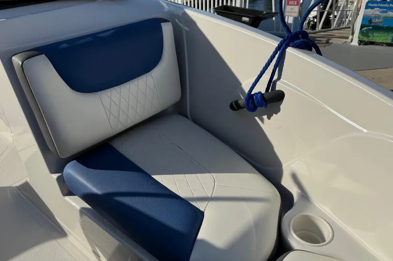 Slide: The Image of 2016 Tahoe 450 TS boat seat with blue and white upholstery, docked with blue rope. - 22