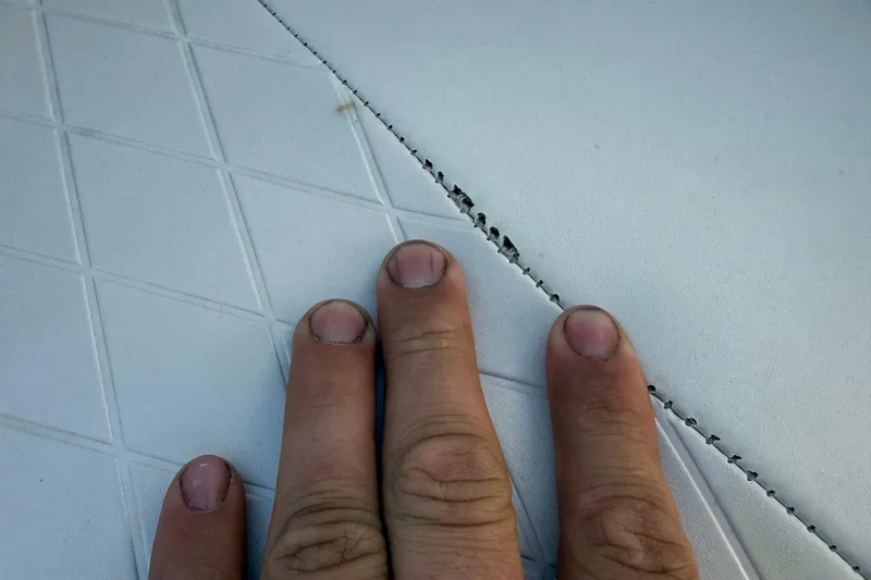 Slide: The Image of Close-up of a hand inspecting stitching on a 2016 Tahoe 450 TS boat seat. - 23