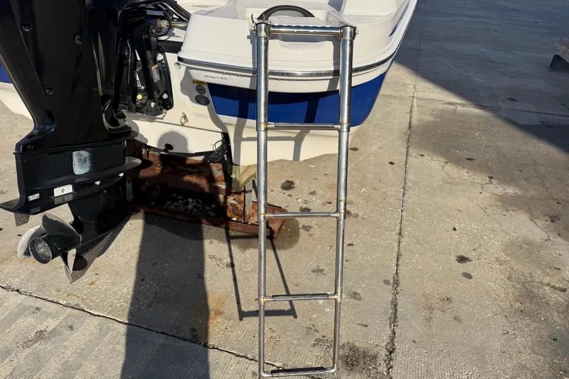 Slide: The Image of 2016 Tahoe 450 TS boat with ladder and outboard motor on concrete surface. - 6