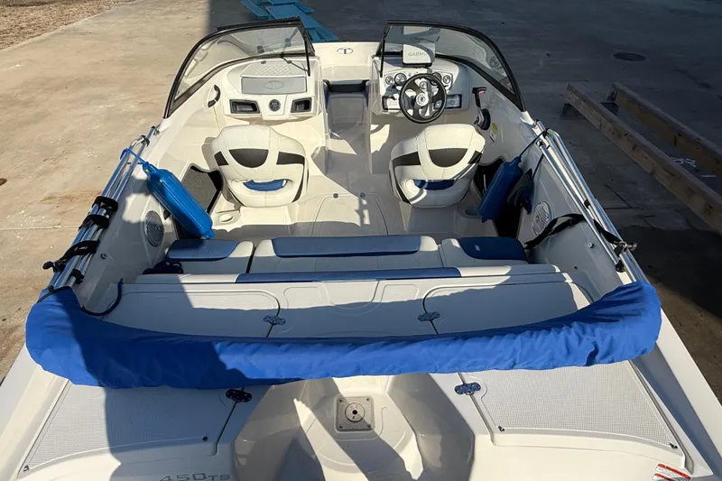 Slide: The Image of 2016 Tahoe 450 TS boat interior with steering wheel and seating, docked on concrete. - 7