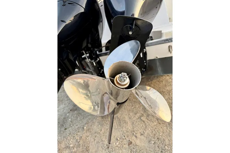 Slide: The Image of Close-up of a 2002 Boston Whaler boat propeller on a sandy surface. - 12