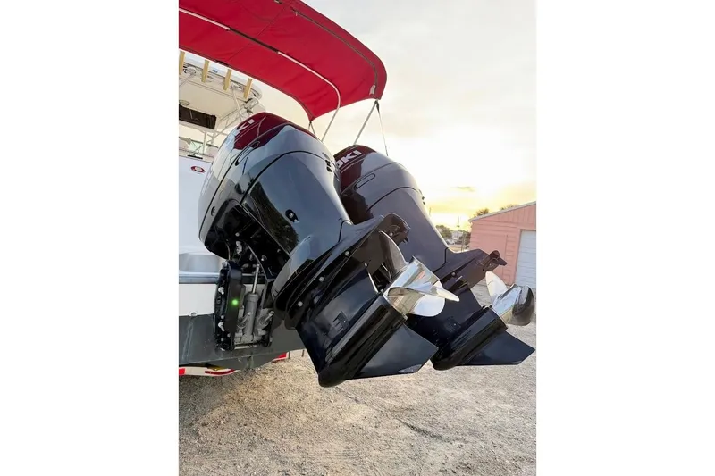 Slide: The Image of Twin outboard motors on a 2002 Boston Whaler boat, with a red canopy overhead. - 17
