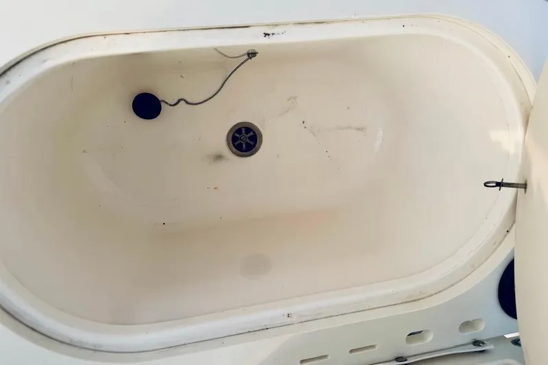 Slide: The Image of 2002 Boston Whaler boat compartment with drain plug and latch. - 25