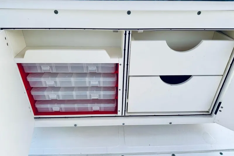 Slide: The Image of Storage compartments on a 2002 Boston Whaler boat, featuring organized tackle boxes and drawers. - 27
