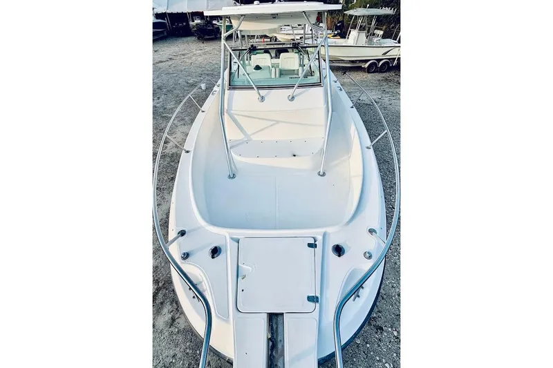 Slide: The Image of 2002 Boston Whaler boat, white exterior, docked on gravel, front view. - 38