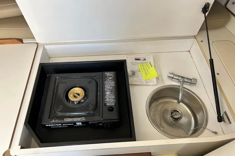 Slide: The Image of 2002 Boston Whaler boat interior with stove and sink setup. - 49