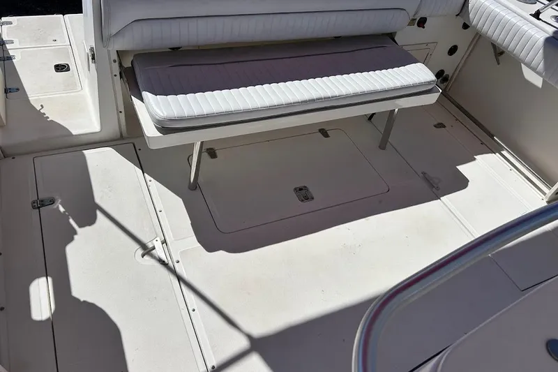 Slide: The Image of 2002 Boston Whaler boat interior with white seating and storage compartments. - 53