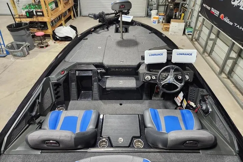 Slide: The Image of 2024 Ranger Z519 boat interior with dual Lowrance displays and blue-accented seats in a workshop. - 2