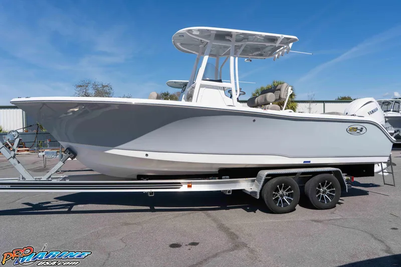Slide: The Image of 2026 Sea Hunt Ultra 229 boat on trailer, displayed outdoors under clear blue sky. - 1