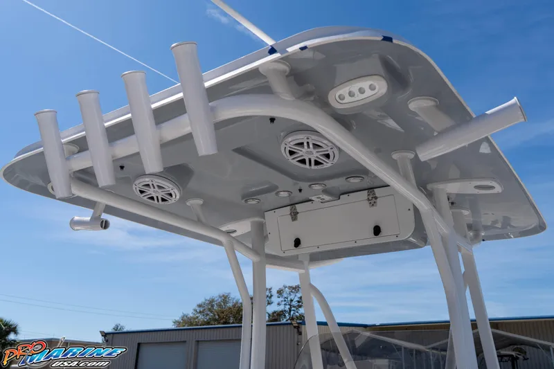 Slide: The Image of 2026 Sea Hunt Ultra 229 T-top with rod holders and speakers under clear blue sky. - 13