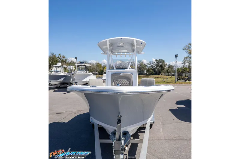 Slide: The Image of 2026 Sea Hunt Ultra 229 boat on trailer under clear blue sky. - 26