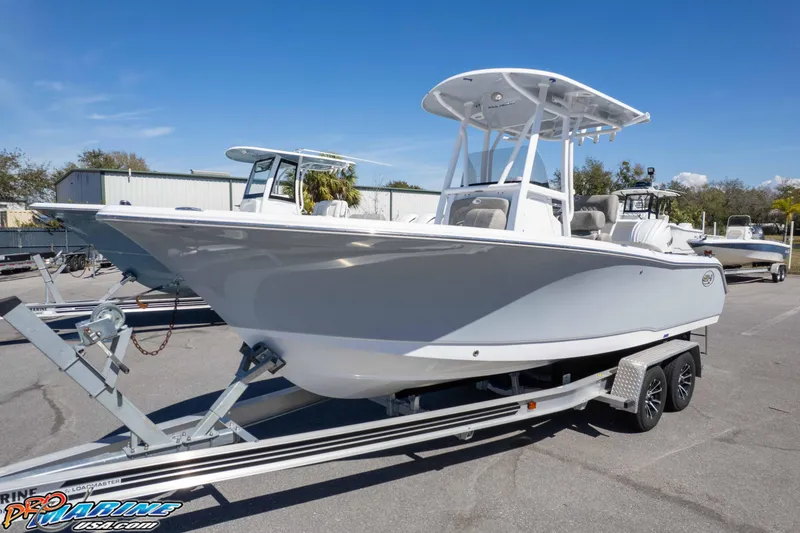 Slide: The Image of 2026 Sea Hunt Ultra 229 boat on trailer under clear blue sky. - 29