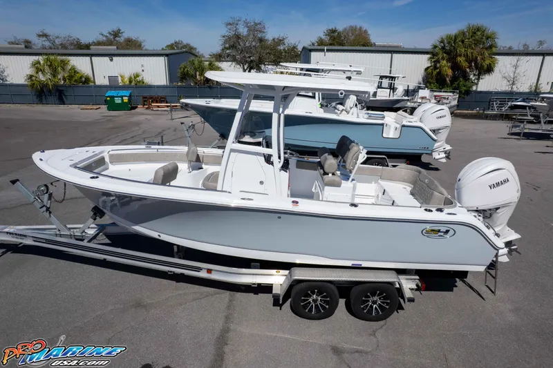 Slide: The Image of 2026 Sea Hunt Ultra 229 boat on trailer, featuring Yamaha engine, parked outdoors. - 32