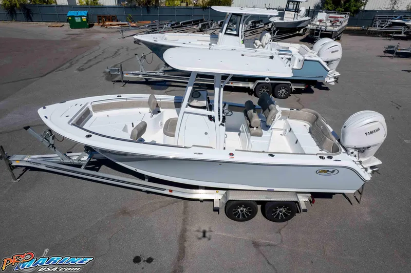Slide: The Image of 2026 Sea Hunt Ultra 229 boat on trailer, featuring Yamaha engine, parked outdoors. - 33