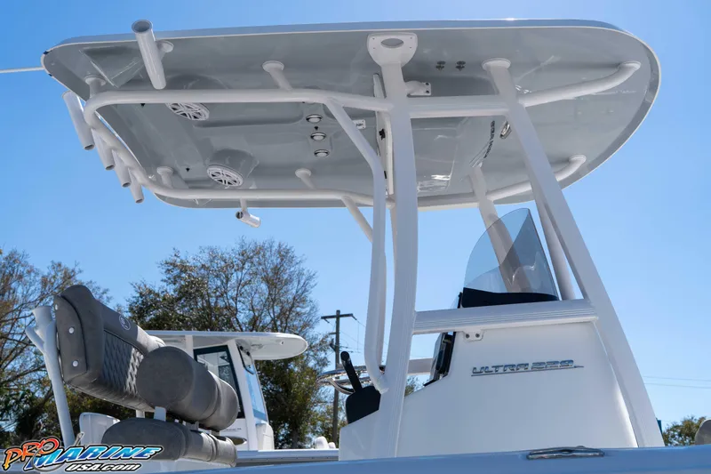 Slide: The Image of 2026 Sea Hunt Ultra 229 boat with T-top and seating, under clear blue sky. - 6