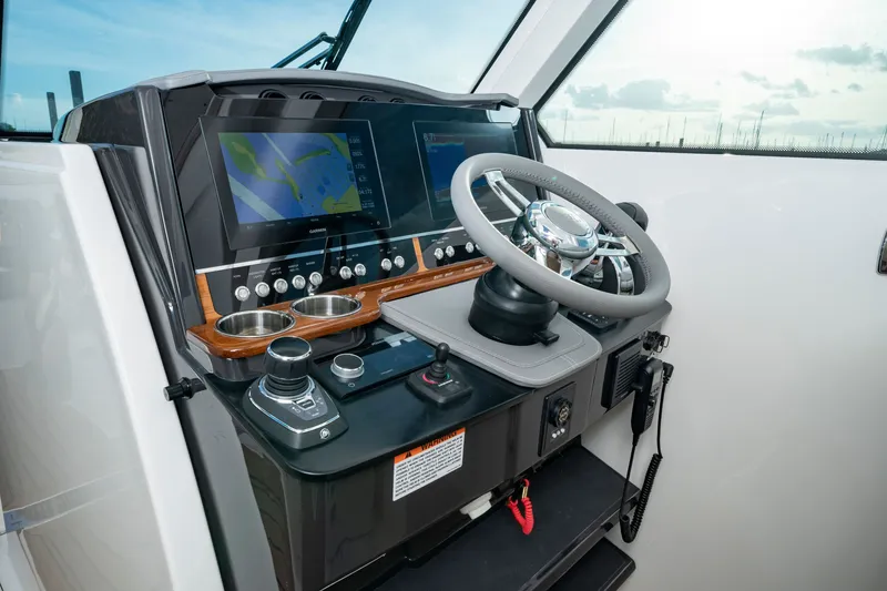 Slide: The Image of The cockpit of the 2027 Tiara Yachts 34lx features modern navigation systems and a sleek steering wheel. - 4