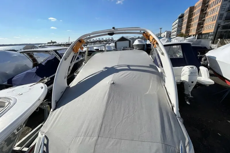 Slide: The Image of Covered 2020 Regal 26 XO boat docked among other vessels under a clear blue sky. - 1