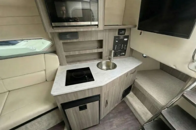 Slide: The Image of 2020 Regal 26 XO boat interior with kitchenette, sink, and seating area. - 10