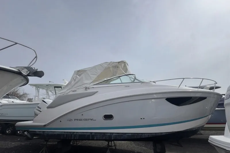Slide: The Image of 2020 Regal 26 XO boat with covered cockpit, displayed outdoors. - 2