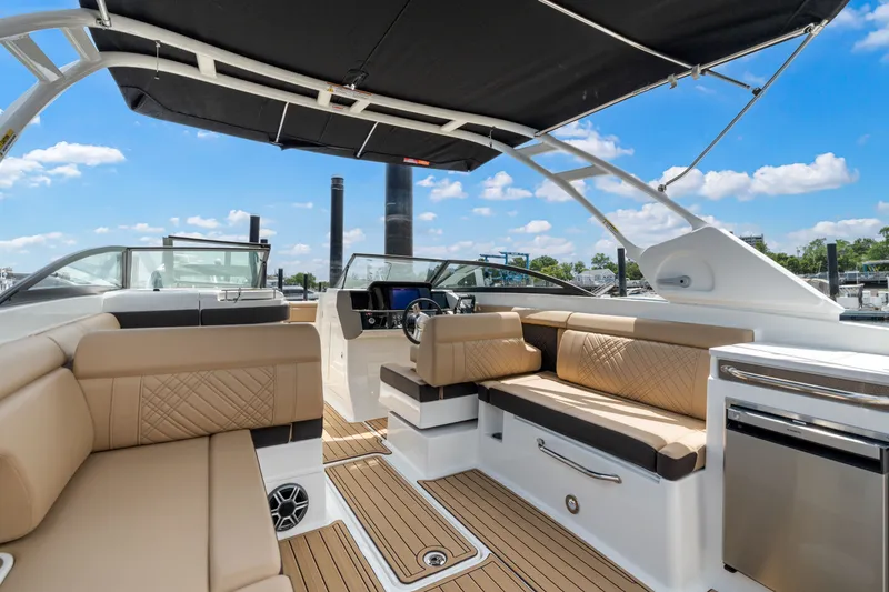 Slide: The Image of The image shows the interior of a 2026 Sea Ray SDX 290 Outboard. It features elegant, modern seating with beige upholstery and a black sunshade. - 12