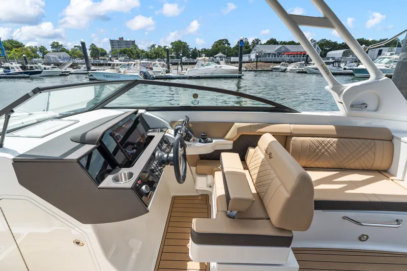 Slide: The Image of The image shows the cockpit of a 2026 Sea Ray SDX 290 Outboard with beige seating and a modern helm. - 14