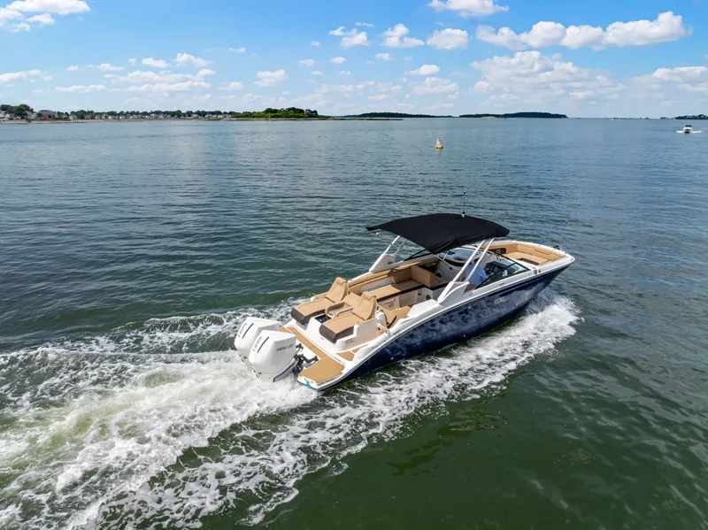 Slide: The Image of A 2026 Sea Ray SDX 290 Outboard cruising on calm waters under a blue sky. - 1