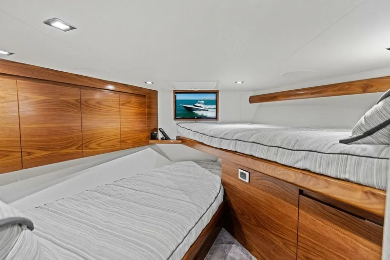 Slide: The Image of Luxurious 2023 Vikiing convertible yacht interior with wooden finishes and cozy bedding. - 27