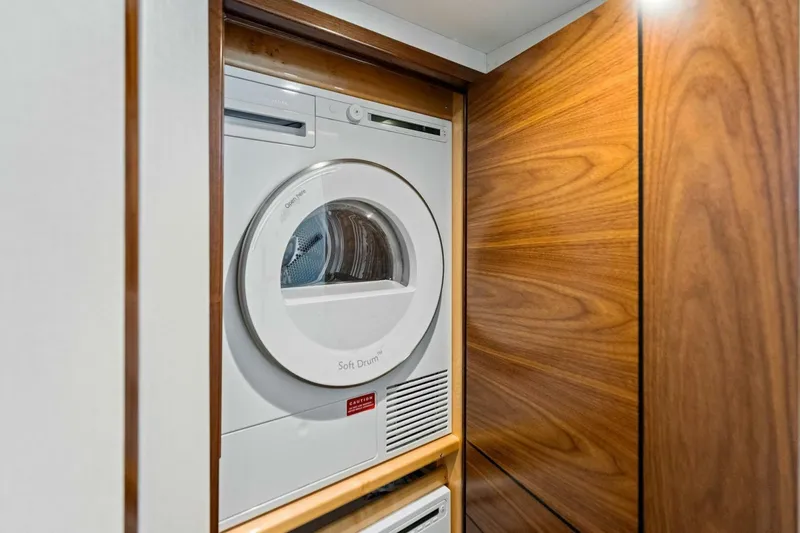 Slide: The Image of 2023 Vikiing convertible laundry area with modern dryer in wooden cabinet. - 29