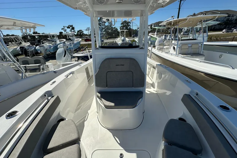 Slide: The Image of 2023 Sea Pro 239 Deep V CC boat interior with seating and console, docked outdoors. - 10