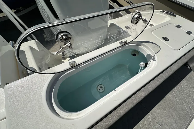 Slide: The Image of 2023 Sea Pro 239 Deep V CC boat livewell with open lid, showcasing interior water. - 16