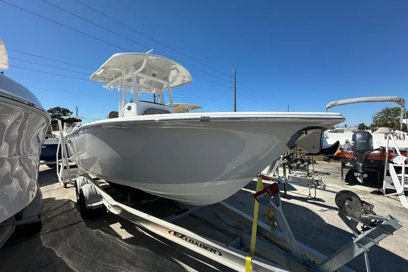 Slide: The Image of 2023 Sea Pro 239 Deep V CC boat on trailer under clear blue sky. - 2