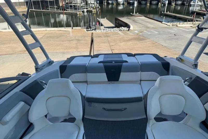 Slide: The Image of 2022 Chapparall 21 SSi boat interior with white seating at a marina. - 8