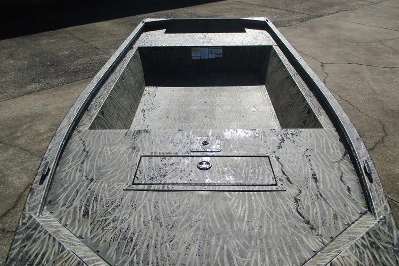 Slide: The Image of 2026 Tracker Grizzly 1648 Utility boat with textured interior, parked on concrete. - 3