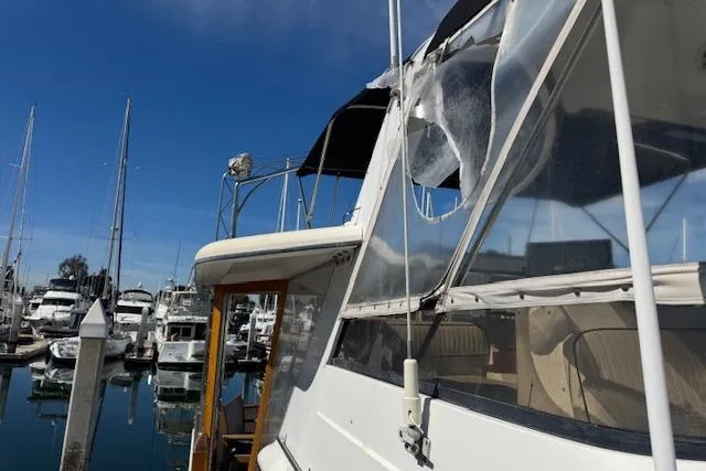 Slide: The Image of 1986 Carver 4207 Aft Cabin Motor Yacht docked at marina under clear blue sky. - 14