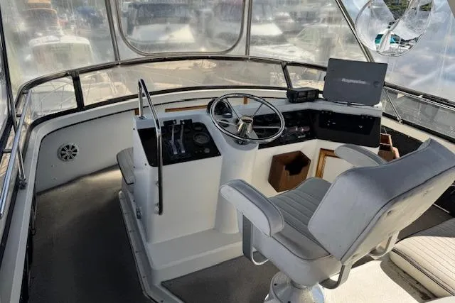 Slide: The Image of 1986 Carver 4207 Aft Cabin Motor Yacht helm with steering wheel and navigation equipment. - 6