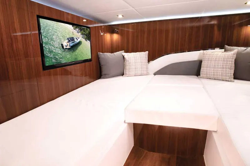 Slide: The Image of 2026 Cruisers Yachts 50 GLS with outdoor kitchen, docked by scenic waterfront. - 11