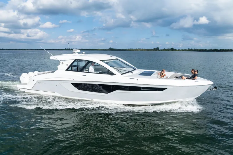 Slide: The Image of 2026 Cruisers Yachts 50 GLS cruising on open water under a partly cloudy sky. - 2