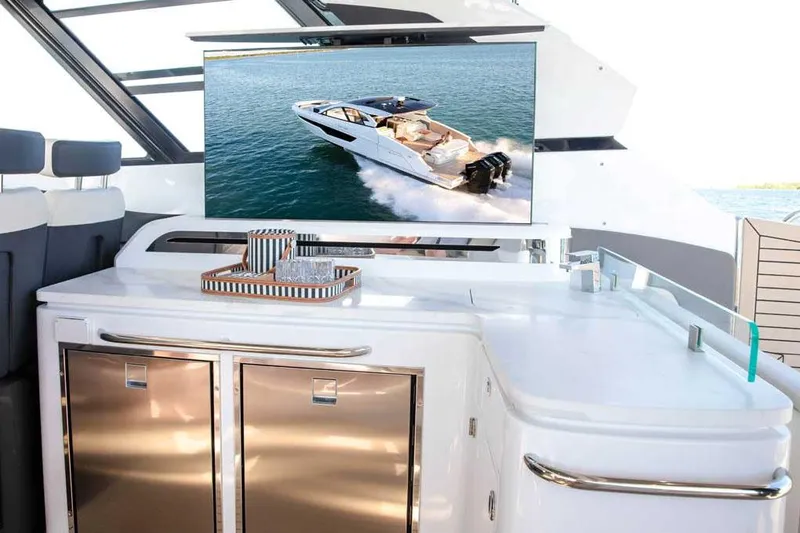 Slide: The Image of 2026 Cruisers Yachts 50 GLS with people enjoying the deck at sunset. - 9