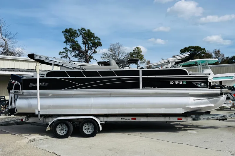 Slide: The Image of 2018 Silver Wave 230 Island CC pontoon boat on trailer, parked outdoors. - 4