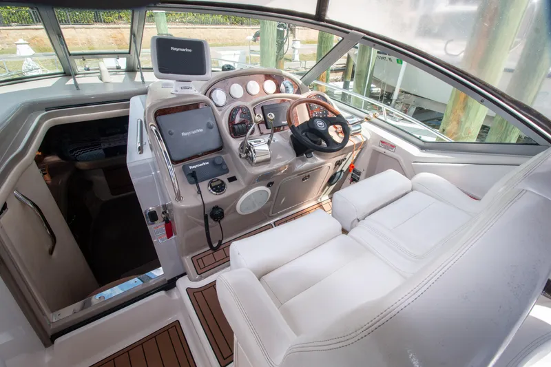 Slide: The Image of 2006 Sea Ray Sundancer 320 cockpit with steering wheel, navigation equipment, and white seating. - 12