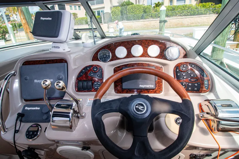 Slide: The Image of 2006 Sea Ray Sundancer 320 helm with Raymarine electronics and wood-accented dashboard. - 14